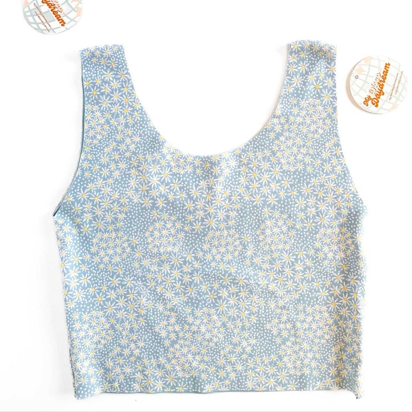 A blue daisy top with one side showing a blue pattern with white daisies.