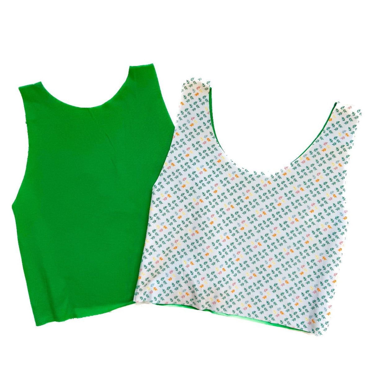 Green sleeveless top and patterned tank top on a white background