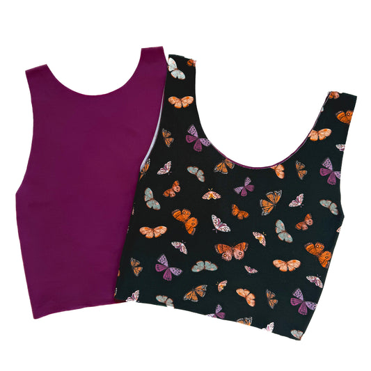 Purple tank top and black tank top with butterfly pattern on a white background