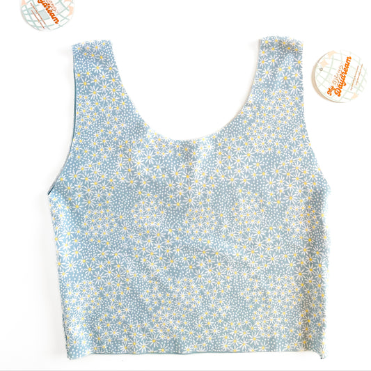 A blue daisy top with one side showing a blue pattern with white daisies.